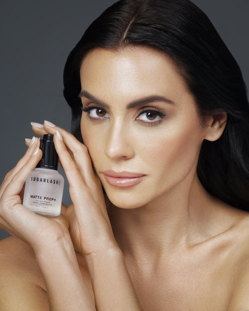 Model holding a Bottle of Matte Prep+ mattifying eyelash extensions primer.