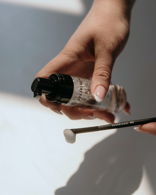 A model pumping lash extensions cleansing base on to a cleaning brush for eyelashes.