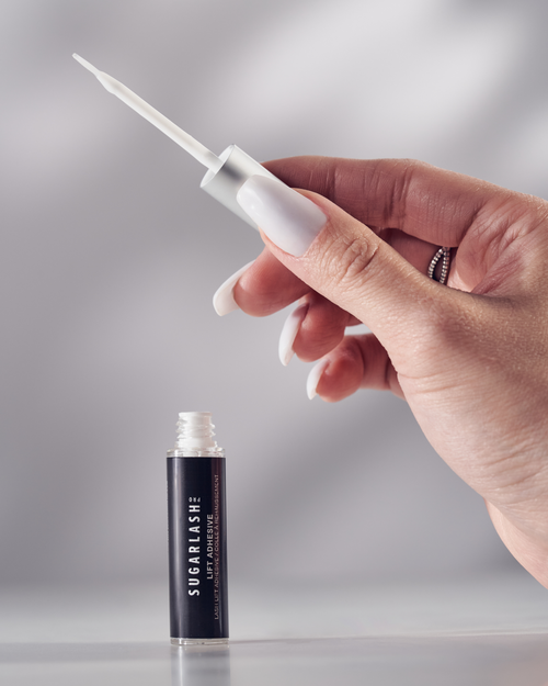 Model holding the professional Lash Lift Adhesive applicator.