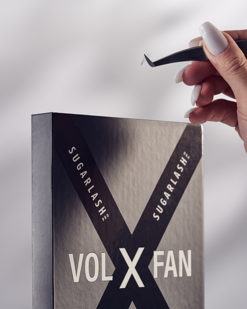 A modeling holding tweezers above a tray of Pre-made Fans for volume lash extensions.